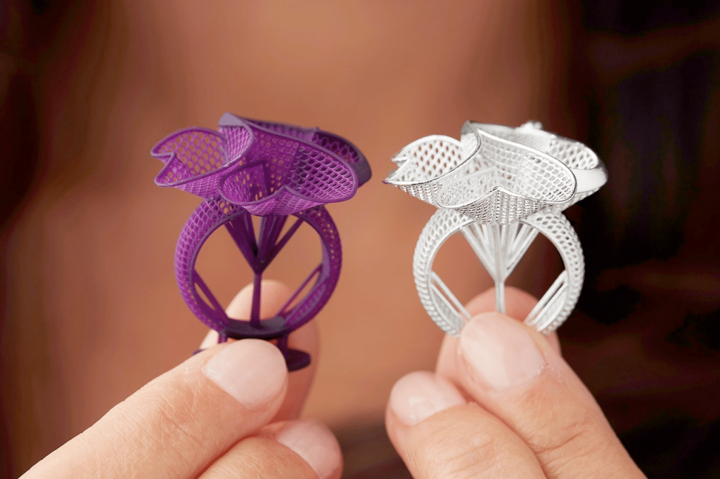 Čovek drži dva prstena proizvedena uz pomoć 3D štampača.